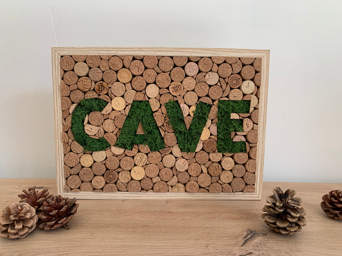 Tableau en bouchons de liège et mousse végétale formant le mot Cave.
