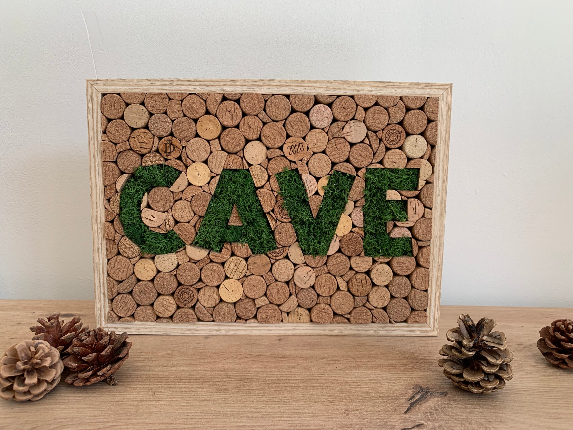 Tableau en bouchons de liège et mousse végétale formant le mot Cave.